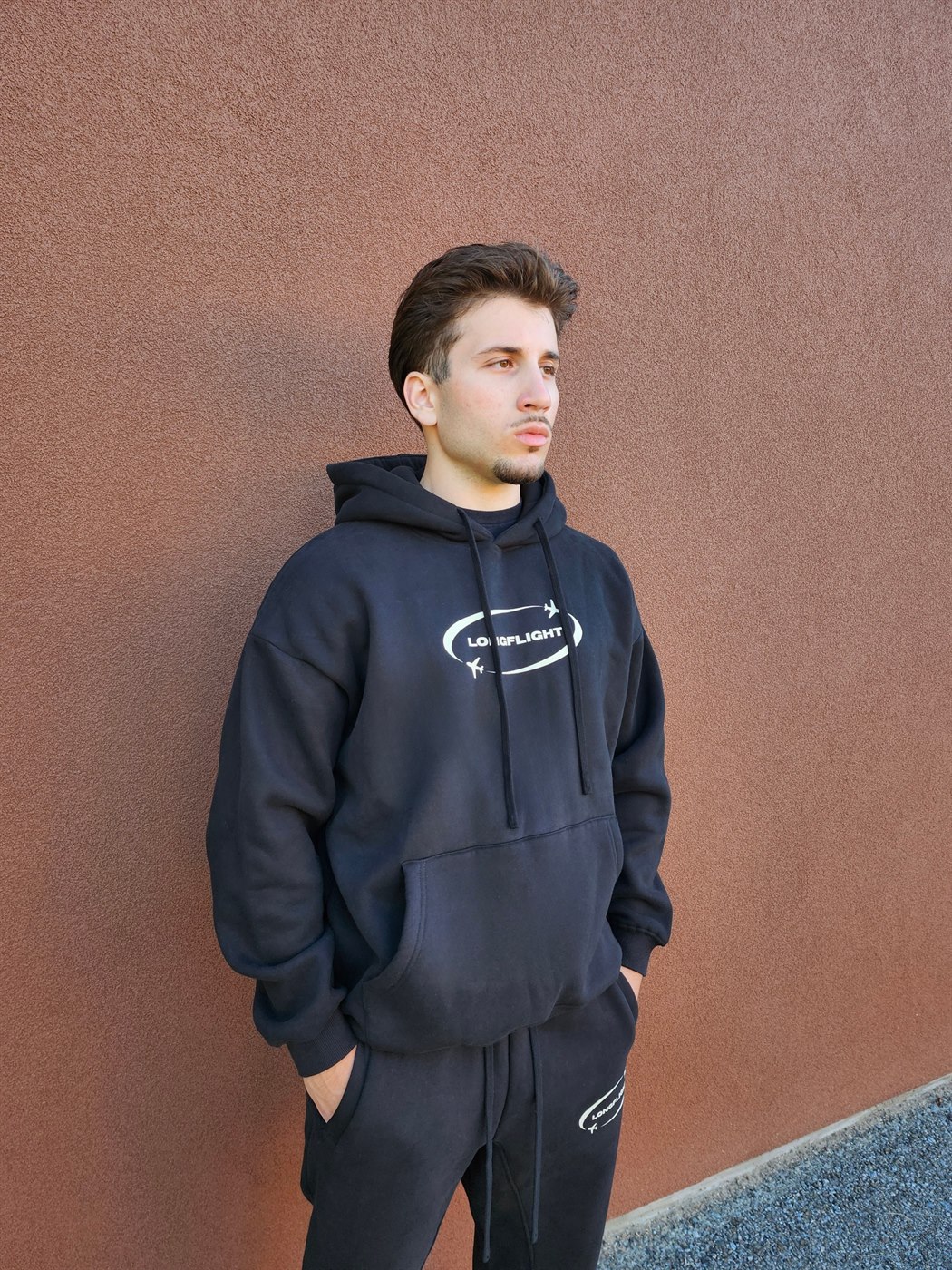 Model wearing the FlightMode Hoodie in black, side