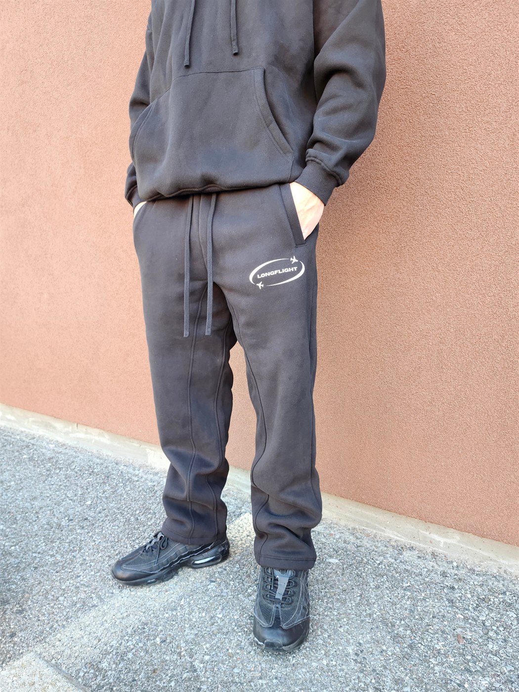 Model wearing the FlightMode Set in black, sweatpants and logo detail