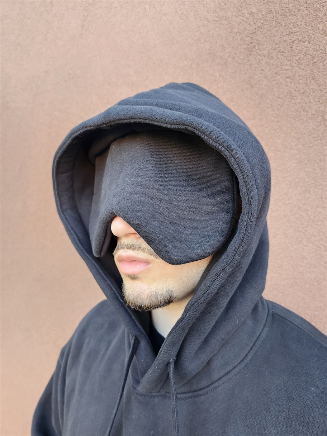 Close-up of the black FlightMode Hoodie worn with the hood up and the hidden eye mask pulled down over the eyes